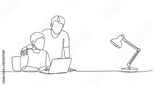 A father and son working together on a laptop with a desk lamp