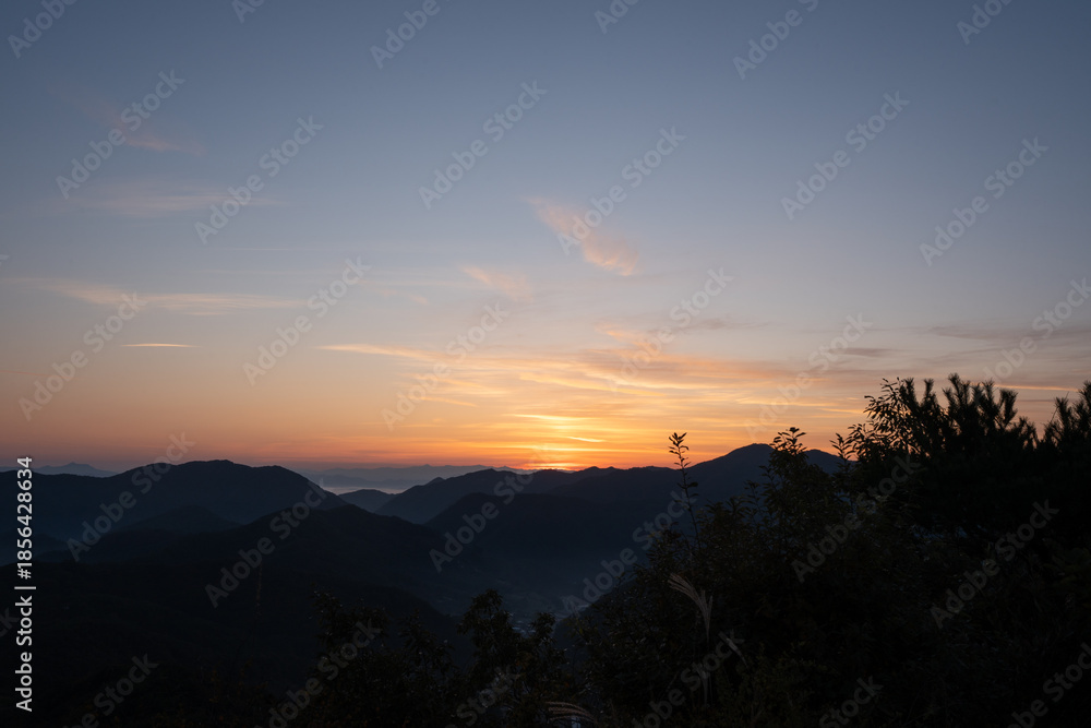 Obraz premium 朝焼けの空と山並み