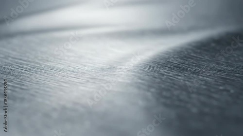 Extreme close-up macro shot of fine brushed silver metal texture subtly rippling and pulsating with soft light reflections and gentle forward movement hightech, architecture, engineering