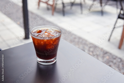 Refreshing glass of iced coffee with milk and ice cubes on a wooden table. Cold brew for a summer drink concept