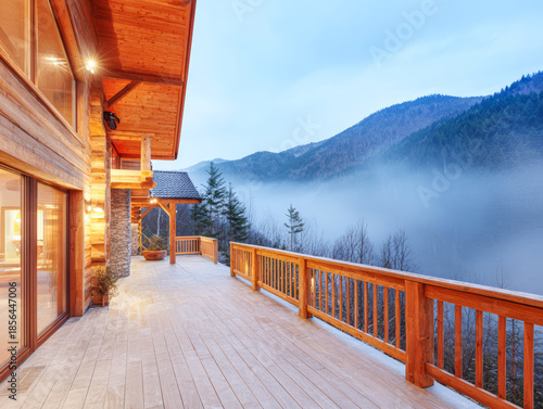View from a wooden deck overlooking mountains and mist during dawn in a mountainous area