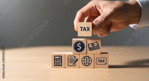 Hand building tax concept with wooden blocks and symbols