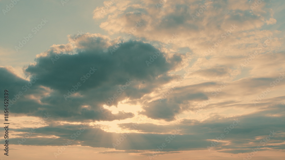 Fototapeta premium A Serene and Beautiful Cloudy Sky with Sunlight Gently Peeking Through the Clouds