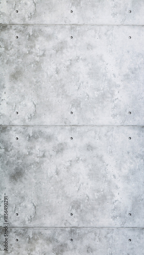 Vertical texture background of exposed concrete wall with tie holes and visible seams in industrial loft style.