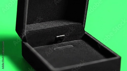 Open black jewelry box on vibrant green background