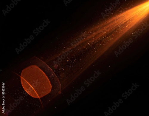 Orange beam of light flares with particles against a dark background
