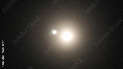 A full moon at night against a black background in the sky.