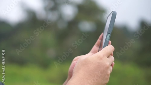 a man's hand holding a smartphone often sees videos scrolling on social media	