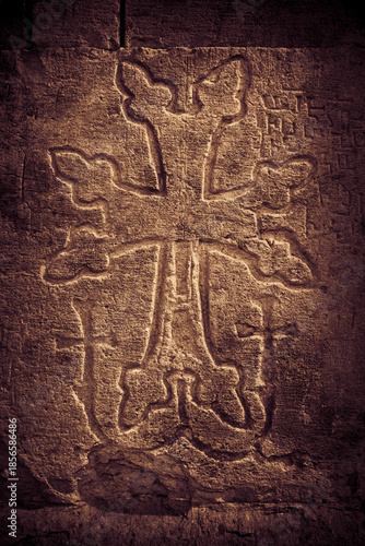 Khachkar - medieval Armenian headstone bearing carved cross, life scenes or decorative interlaces and botanical motifs. Close up sepia toned image