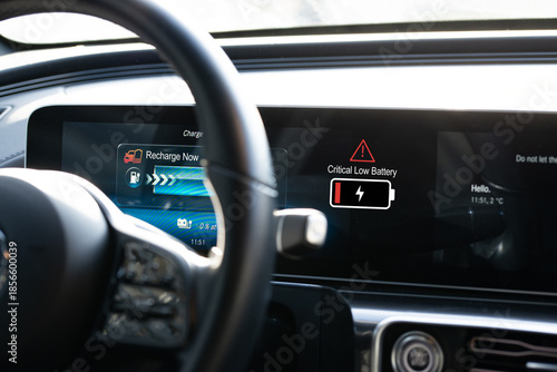 Electric vehicle range anxiety concept with low battery indicator on car dashboard