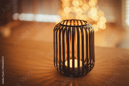 Christmas candle and Christmas lights. In background Christmas tree.