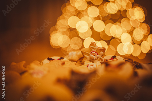 Christmas cookies close up. Christmas cookies on a glass tray. In background Christmas tree. Christmas lights.