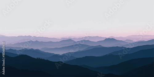 A breathtaking morning landscape of misty mountains at sunrise with a blue sky and forest trees visible through the fog and clouds over a vast valley horizon.
