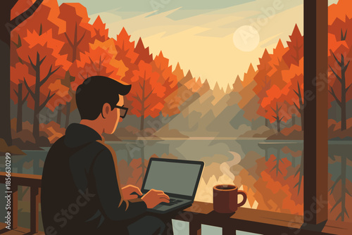 Person works on laptop by a lake during fall with trees and sunset in background