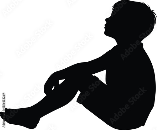 Black silhouette of a young boy sitting on the ground, child profile looking up, isolated vector shape for childhood design,