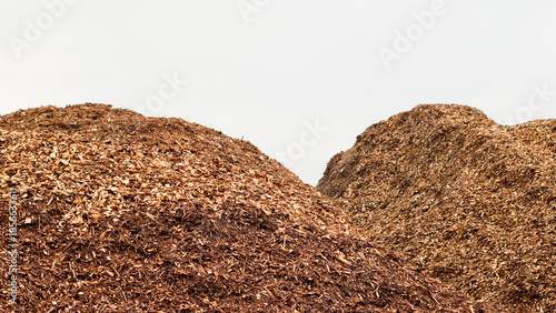 Фотография Mountains of wood chips against a gray sky close-up