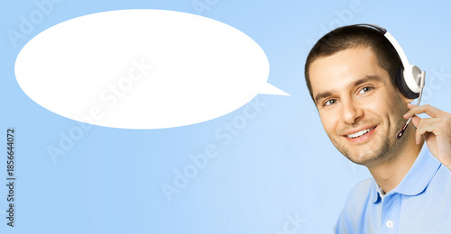 Representative call center. Happy smiling man callcenter support phone operator in microphone headset, isolated blue background with white empty mockup speech bubble. Customer callcenter service help