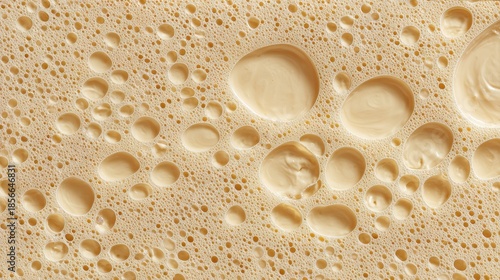 Macro view of creamy liquid with delicate foam and large droplets.
