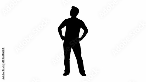 Silhouette of a man standing with hands on hips looking up.