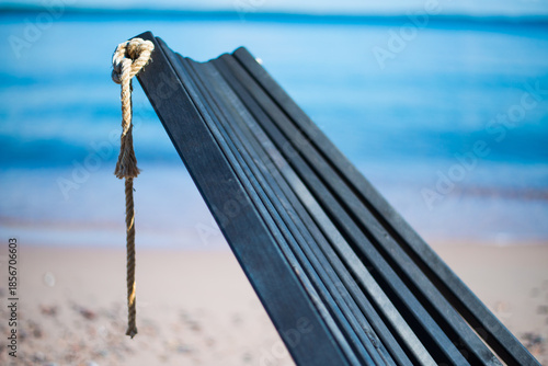 Obraz na plátně Close-up of Wooden Beach Chair Backrest with Rope Knot on Sandy Shore at Isosaar