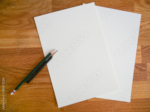 Blank Textured Paper Sheets with Pencils on Wooden Desk