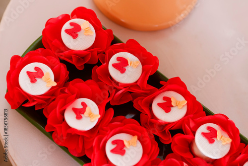 Festive sweets in red floral paper liners with number 2 and butterfly