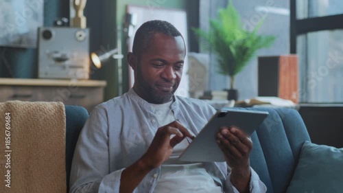 Person enjoys digital entertainment calmly, Individual sitting peacefully engaging with devices and art