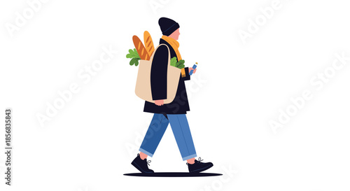 A person wearing winter clothes walking and carrying a reusable tote bag full of groceries like bread and fresh vegetables.