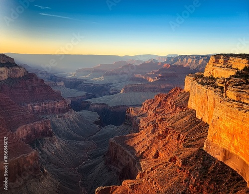 vast layered canyon vista with sunlit cliffs at dawn shadows deepening within
