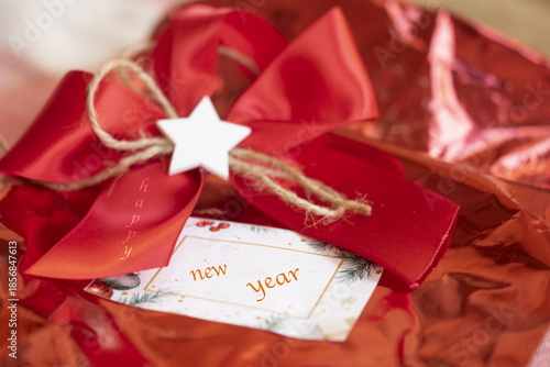 Happy New Year written on a red decoration and a greeting card