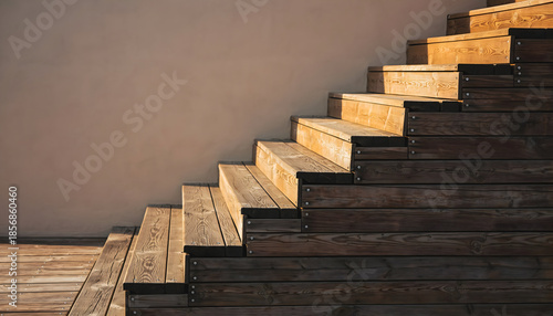 Warm Golden Sunlight Illuminates Rustic Wooden Outdoor Staircase Ascending Against a Textured Beige Wall Architectural Detail in Natural Light