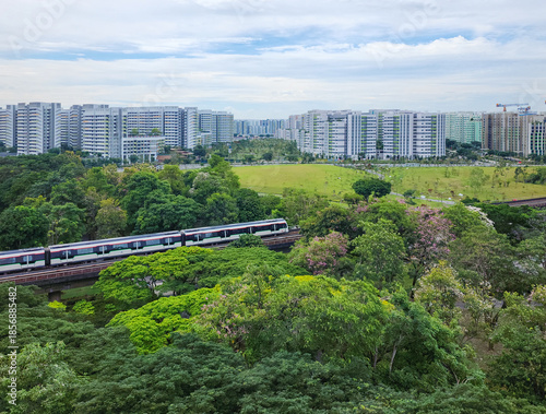 A train passed by the Sun Plaza Park, Tampines heartland district during bloom season - Singapore.