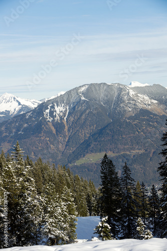 Beautiful panorama of high rocky mountains with snowy peaks against the blue sky and clouds. Brandnertal, Austria
