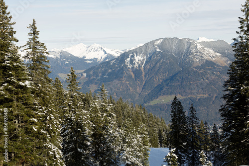 Beautiful panorama of high rocky mountains with snowy peaks against the blue sky and clouds. Brandnertal, Austria