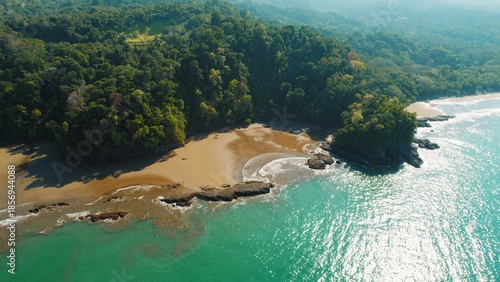 Aerial view of a secluded rainforest bay in Costa Rica in dry season on sunny day.