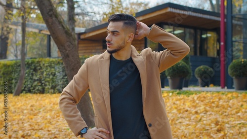 Slika na platnu Worried Hispanic man guy in autumn park look around waiting for meeting looking