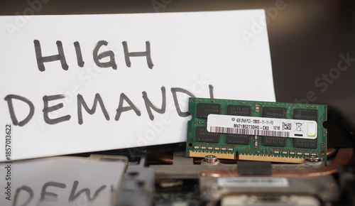 Foto A DDR3 RAM stick resting on a laptop with a handwritten HIGH DEMAND! sign