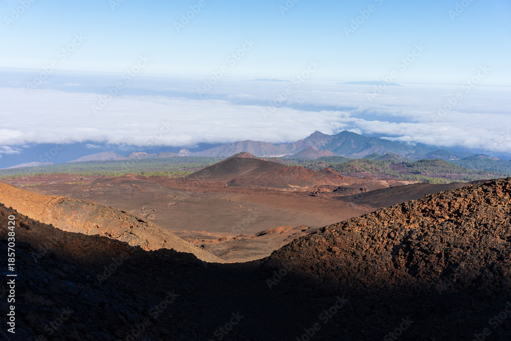 Naklejka premium View from the trail to Pico Viejo over volcanic cones, lava fields, pine forest and sea of clouds in Teide caldera, Teide National Park, Tenerife, Canary Islands, Spain.
