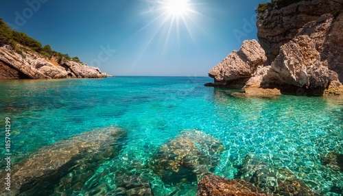 clear turquoise water laps against sunlit rocks