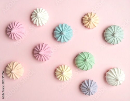 カラフルなメレンゲ菓子が並んだピンクの背景
