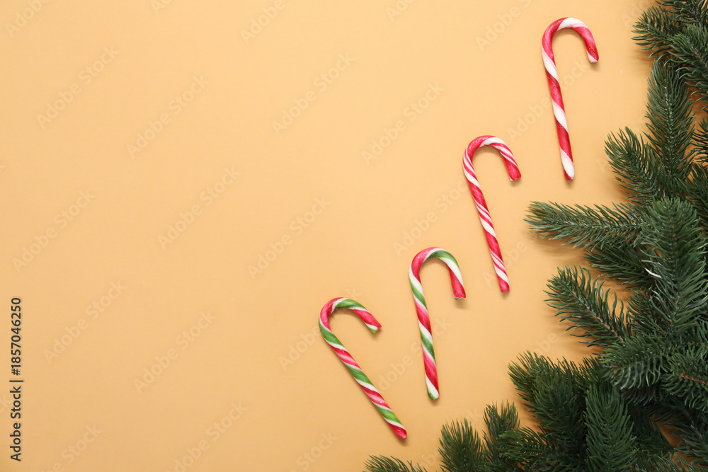 Obraz premium Flat lay composition with candy canes on pale orange background, space for text. Christmas treat