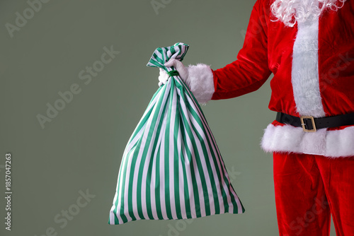 Photos Santa Claus holding sack on grey background, closeup with space for text