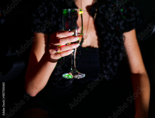 Wallpaper Mural Evening Celebration: Woman Holding Sparkling Wine Glass Illuminated by Ambient Club Lights Close-Up Torontodigital.ca