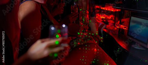 Wallpaper Mural Nightlife: Group of Friends Socializing with Drinks in Vibrant Bar Under Colorful Lights Torontodigital.ca