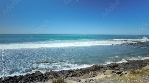 Walking along rocky coastline with ocean view on sunny day