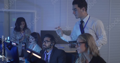 A focused team wearing headsets monitors live analytics dashboards and collaborates in modern control room. Highlighting customer support, data driven decision making, coordinated incident response.
