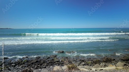 Calm ocean view from rocky shore on sunny day
