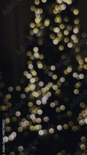 Abstract bokeh footage of Christmas tree lights at night. Warm glowing holiday lights with soft focus, perfect for New Year visuals, festive intros, and seasonal designs.