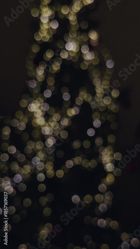Defocused Christmas tree lights creating warm golden bokeh. Cozy holiday atmosphere with soft glowing circles, ideal for winter, celebration, and seasonal video backgrounds.