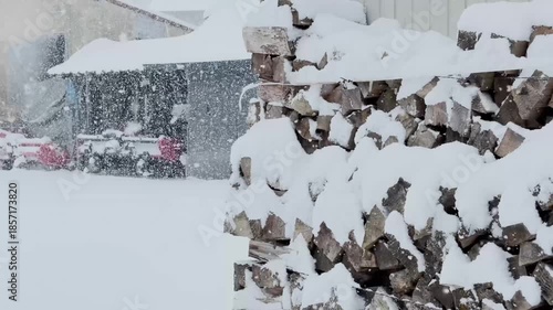 雪が降る田舎の風景　まき　冬　建物　小屋　農機具